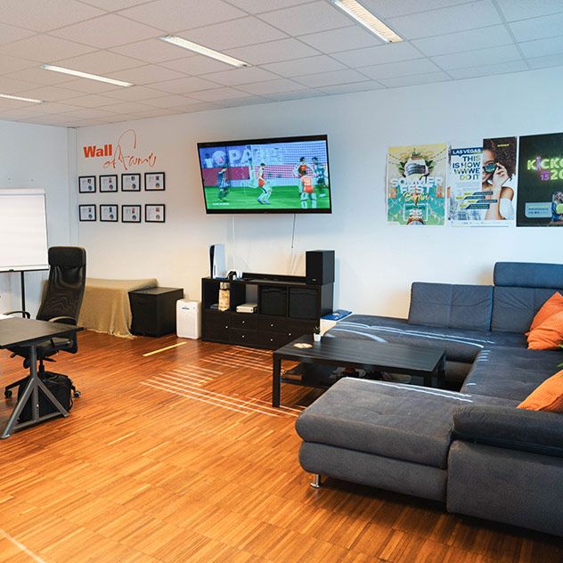 Hintere rechte Ecke des Office Wien Nord mit großem Sofa und FIFA-Spiel