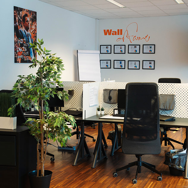 Schreibtische mit Trennwänden und Blick auf die Wall of Fame