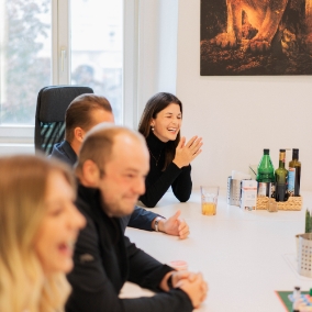 Vier Mitarbeiter im Meeting an einem weißen Tisch